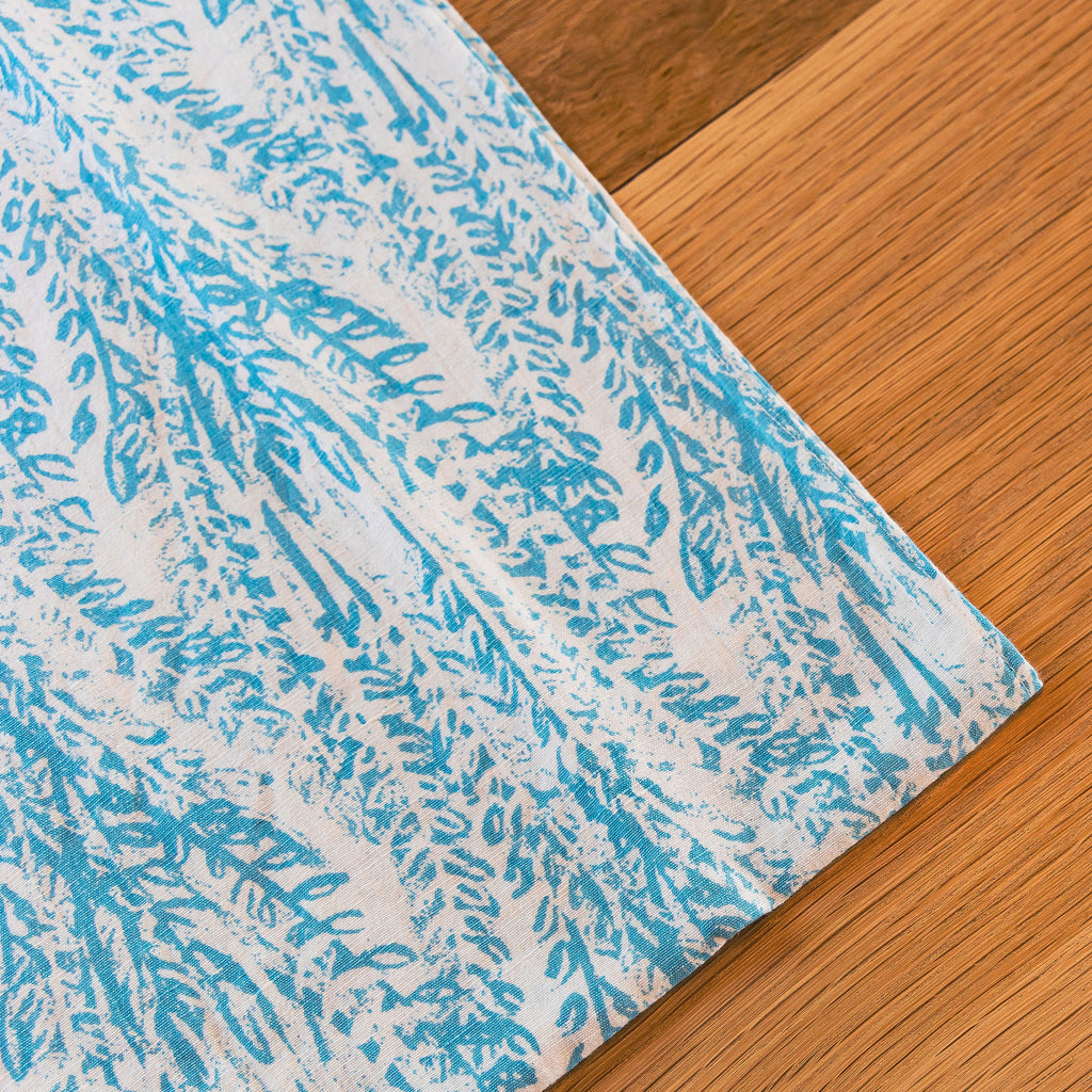 The Laguna Table Runner in contrast with wooden dining table. Set for any occasion.