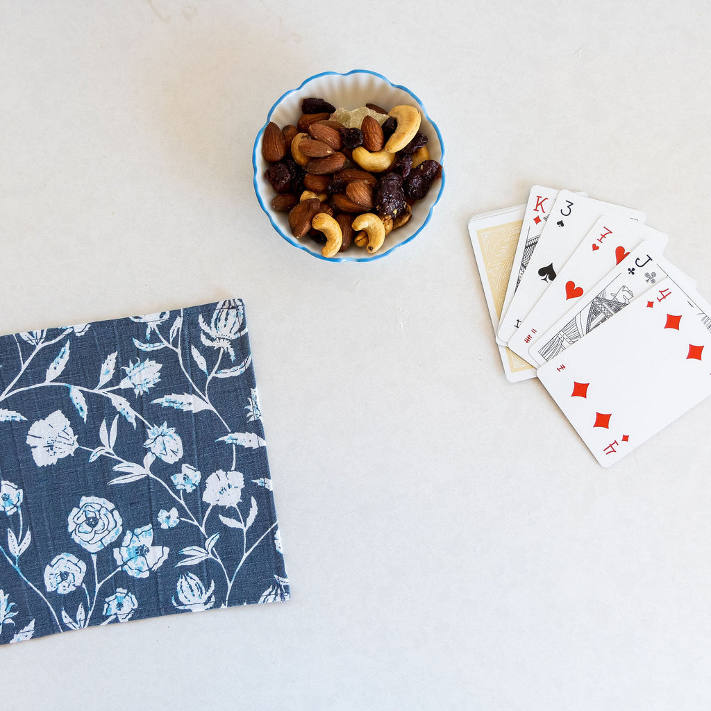 A luxurious Montecito Cocktail napkin complements the perfect game night. Vibrant blue floral hues make this collection a standout.