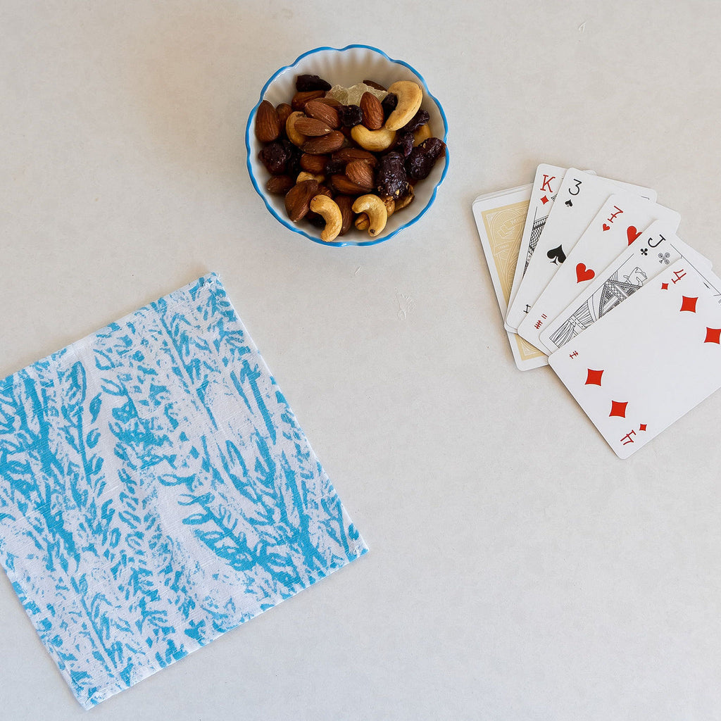 Featuring a cocktail napkin from the Laguna collection. Vibrant blue and white foliage print complement a perfect game night.